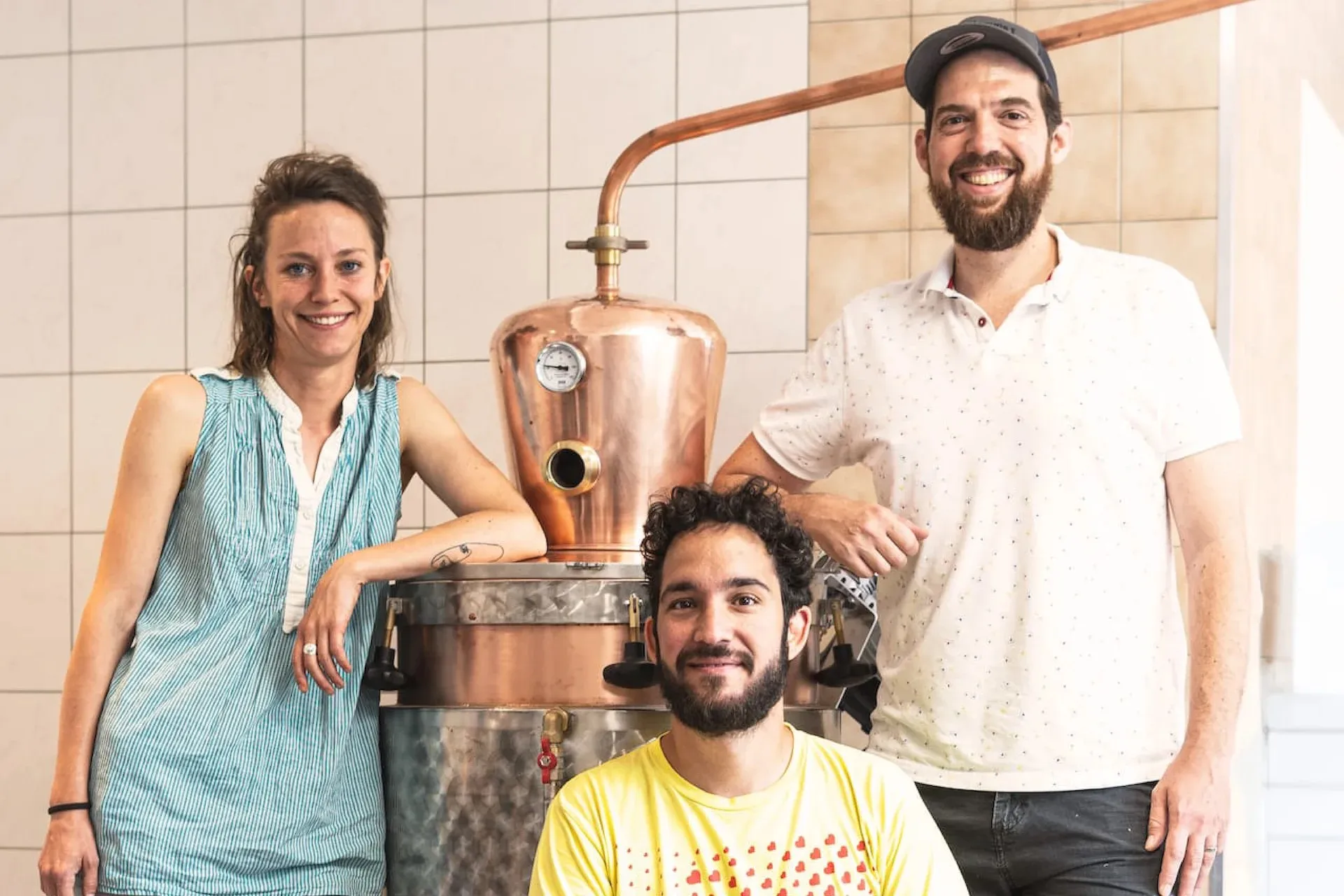 Céline, Julien et David, les fondateurs de Stillerie, devant le grand alambic en cuivre de la distillerie